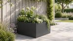 Grauer, quadratischer Pflanzkübel Alessio 13 aus Aluminium mit Hortensien, Lavendel und weißen Blüten vor einem hellen Gartenzaun