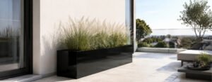Blog 63 Schwarzer Aluminium-Pflanzkübel Edoardo 13 in glänzender Optik mit dekorativem Ziergras auf einem hellen, modernen Balkon